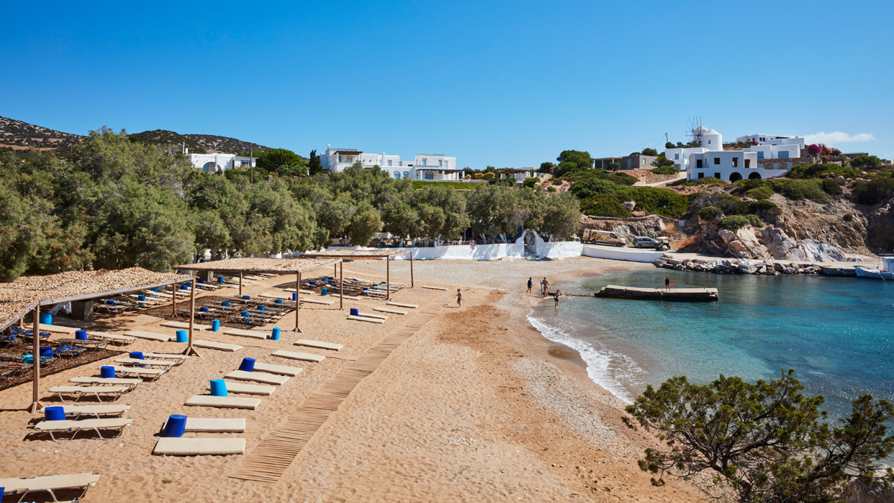A sandy beach with sunshades on Antiparos, next to Paros